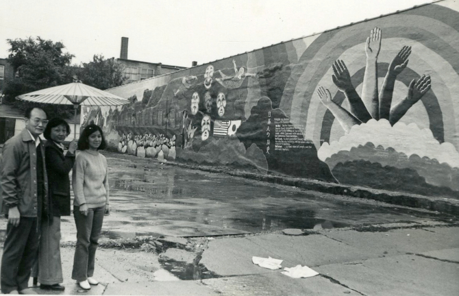 JASC Executive Director Masaru Nambu, Board President Lillian Kimura, and Board Secretary Diane Kayano front of the "History of the Japanese Americans" mural on the exterior of JASC's building at 4427 N Clark St, 1973, folder 15, box 17, in Record Grou